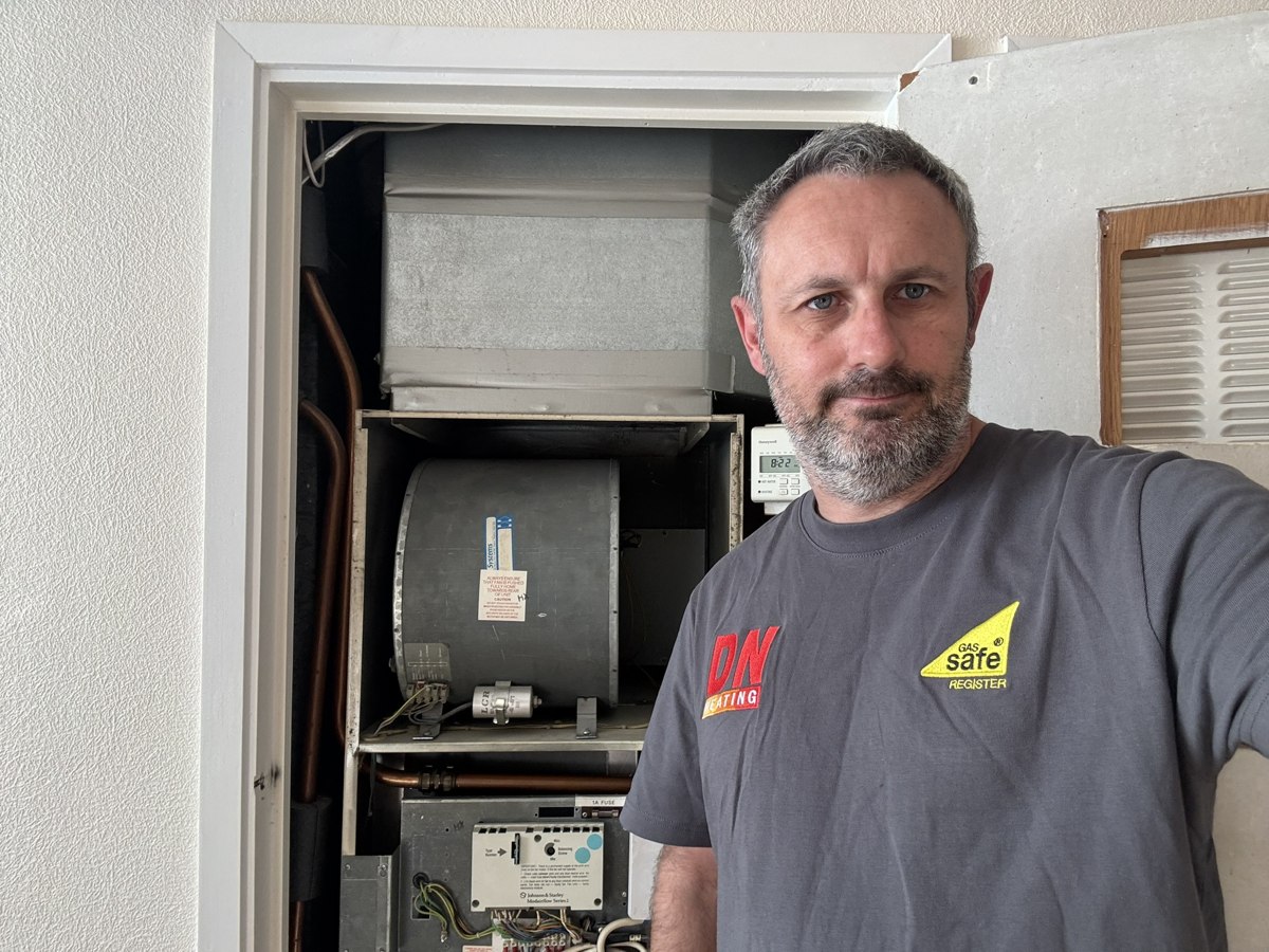 Darren of DN Heating beside a Johnson and Starley warm air unit